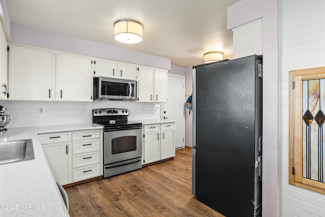 607 N 53rd Ave, Yakima, WA 98908 - kitchen with stainless steel appliances, dark wood-style flooring, backsplash, light countertops, and white cabinetry