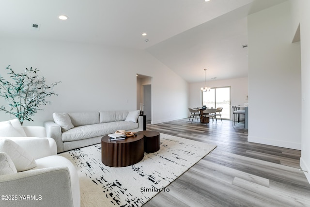 living room with baseboards, lofted ceiling, wood finished floors, an inviting chandelier, and recessed lighting