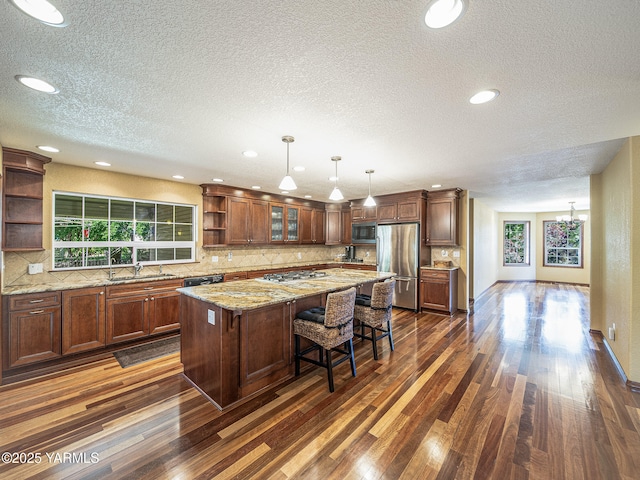 9203 W Yakima Ct, Yakima, WA 98908 - kitchen with open shelves, appliances with stainless steel finishes, a textured ceiling, a sink, and dark wood-type flooring
