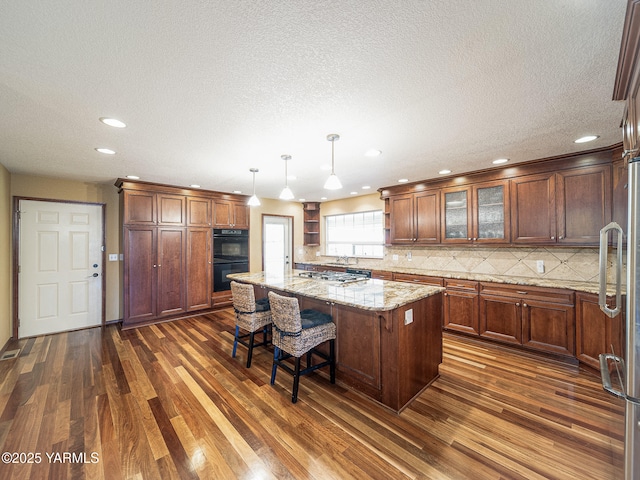 9203 W Yakima Ct, Yakima, WA 98908 - kitchen with stainless steel appliances, dark wood-style floors, a center island, backsplash, and recessed lighting