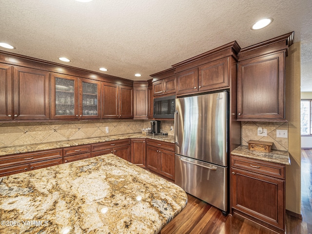 9203 W Yakima Ct, Yakima, WA 98908 - kitchen with freestanding refrigerator, a textured ceiling, dark wood-style floors, glass insert cabinets, and black microwave