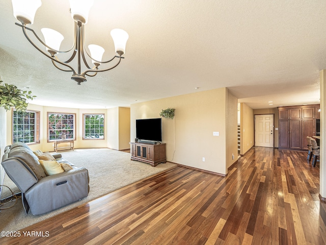9203 W Yakima Ct, Yakima, WA 98908 - unfurnished living room with a textured ceiling, dark wood-style flooring, a chandelier, and baseboards