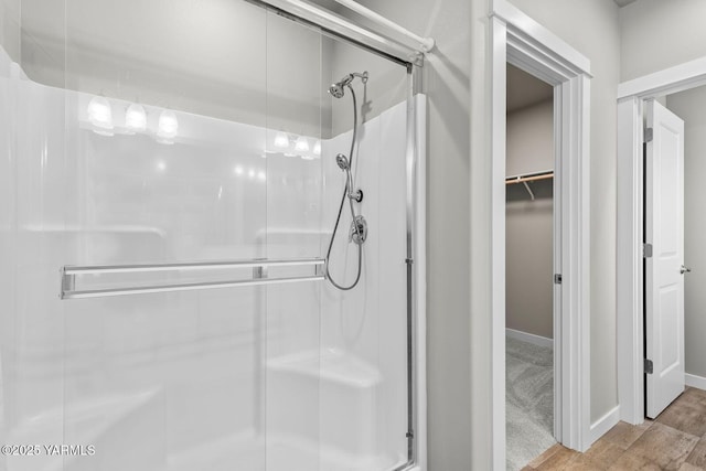 2300 S 57th Ave, Yakima, WA 98903 - bathroom featuring a shower stall, wood finished floors, baseboards, and a walk in closet