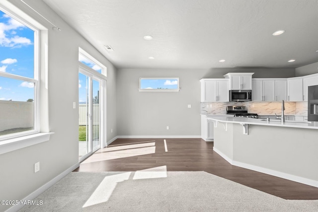 2300 S 57th Ave, Yakima, WA 98903 - kitchen with stainless steel appliances, light countertops, white cabinetry, recessed lighting, and a kitchen breakfast bar