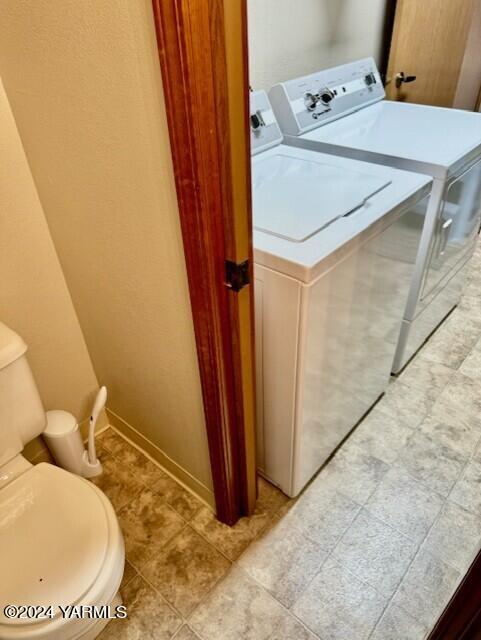 laundry room with laundry area, washing machine and clothes dryer, and baseboards