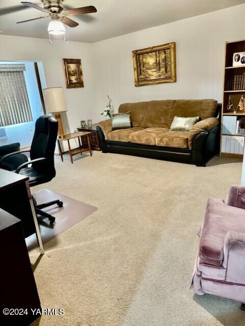 carpeted office space with a ceiling fan