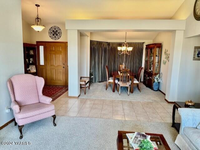 carpeted dining space featuring baseboards, a chandelier, and tile patterned floors