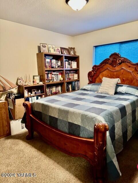 bedroom with carpet floors and a textured ceiling