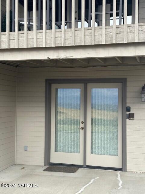 property entrance with a patio area and a balcony