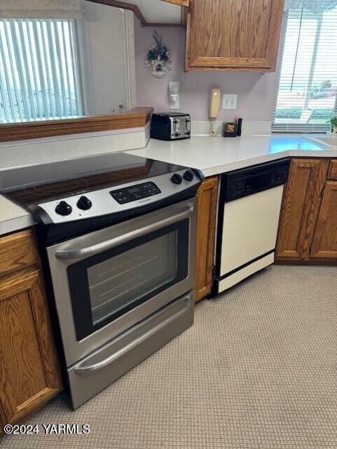 kitchen featuring brown cabinets, light countertops, dishwasher, and stainless steel electric stove