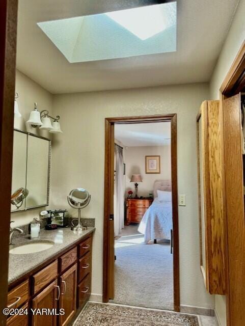 ensuite bathroom with ensuite bathroom, a skylight, and vanity