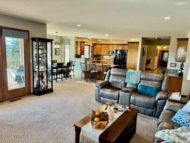 living room with light carpet, visible vents, and recessed lighting