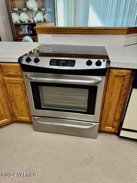 details with light countertops, brown cabinets, and stainless steel electric range