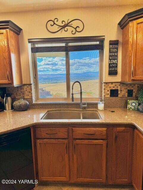 kitchen with dishwasher, brown cabinets, a sink, and decorative backsplash