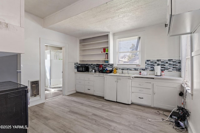 204 S 8th St, Yakima, WA 98901 - kitchen featuring heating unit, backsplash, light countertops, a textured ceiling, and light wood-type flooring