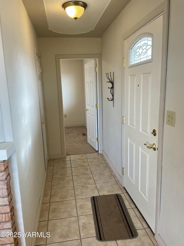 entryway with light tile patterned floors and baseboards