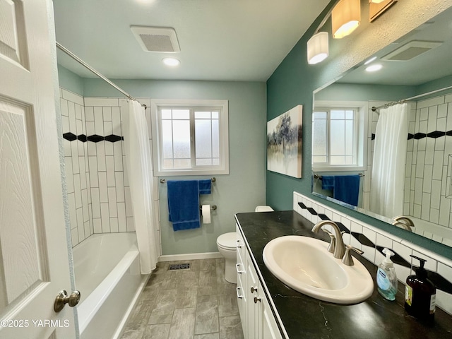 full bathroom with toilet, baseboards, visible vents, and vanity