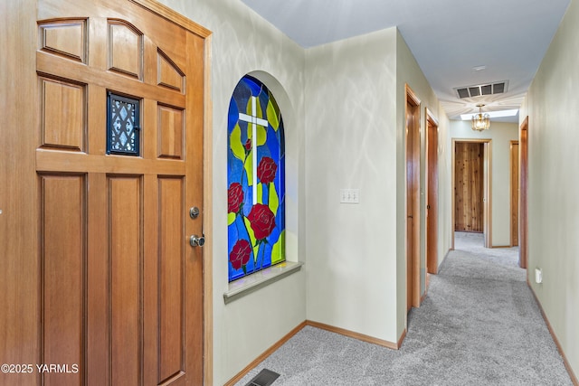 interior space featuring visible vents, baseboards, and light colored carpet