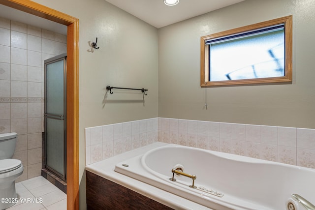 bathroom with toilet, tile patterned floors, tile walls, a shower stall, and a garden tub