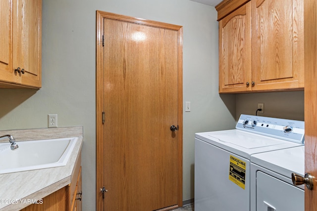 clothes washing area featuring cabinet space, separate washer and dryer, and a sink