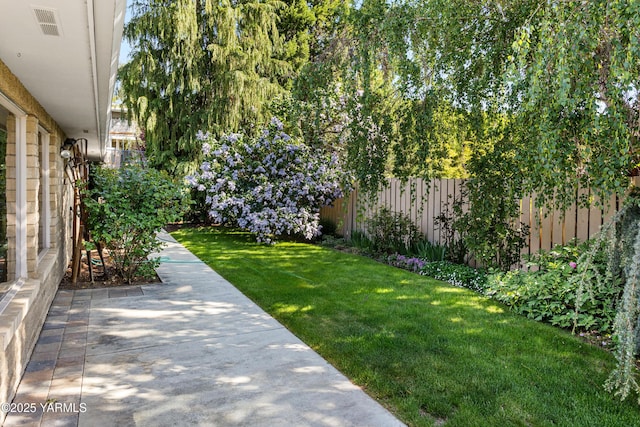 view of yard featuring a patio, visible vents, and fence