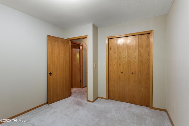 unfurnished bedroom featuring a closet, carpet flooring, and baseboards