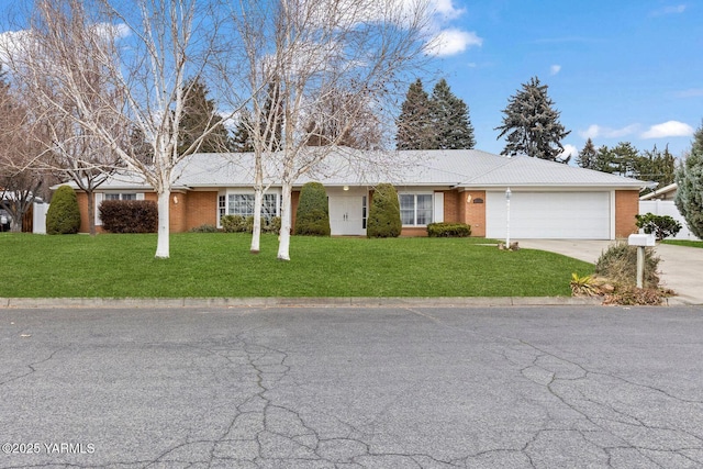 single story home featuring a front yard, brick siding, an attached garage, and driveway