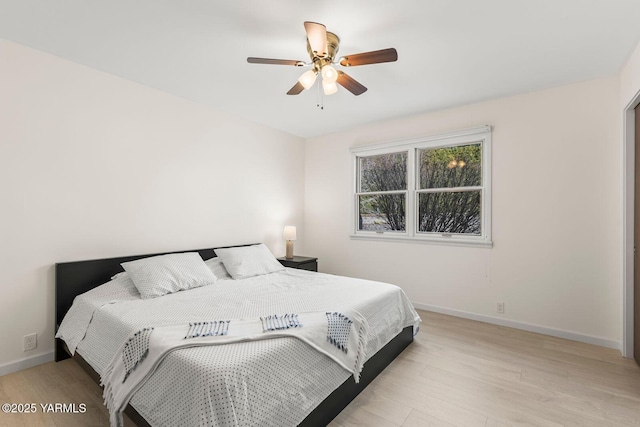 bedroom with light wood-style floors, baseboards, and a ceiling fan