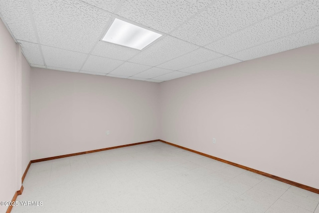 spare room with baseboards and a drop ceiling