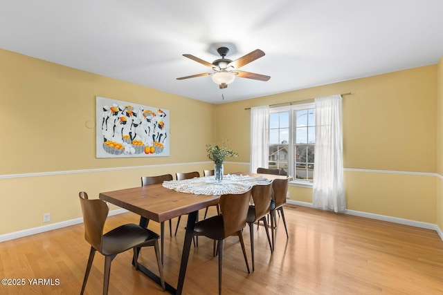 dining space featuring baseboards, light wood-style floors, and ceiling fan