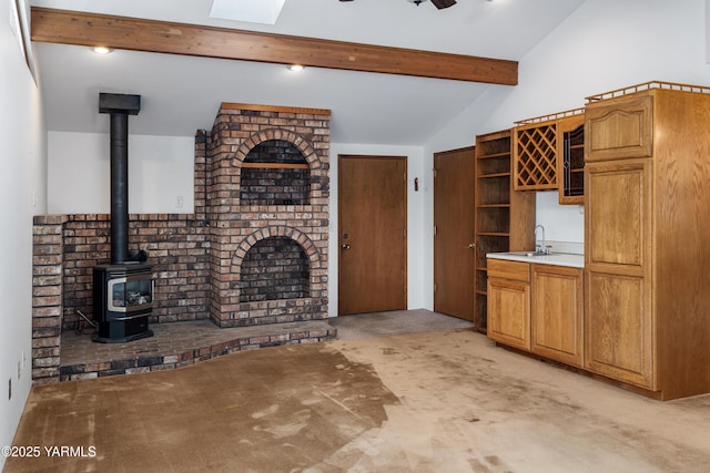 6520 Barge St, Yakima, WA 98908 - unfurnished living room featuring a sink, lofted ceiling with beams, a wood stove, bar, and light colored carpet