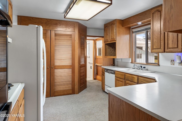6520 Barge St, Yakima, WA 98908 - kitchen with light countertops, white appliances, a sink, light carpet, and brown cabinets