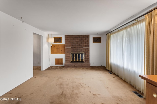 6520 Barge St, Yakima, WA 98908 - unfurnished living room with a brick fireplace, light colored carpet, and visible vents
