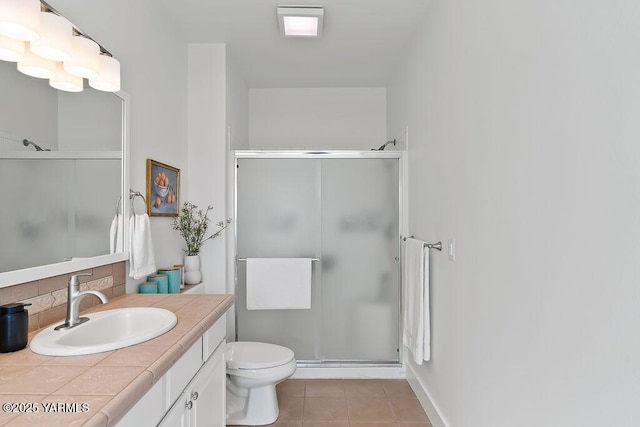 703 S 87th Ave, Yakima, WA 98908 - full bathroom featuring vanity, decorative backsplash, a shower stall, tile patterned flooring, and toilet
