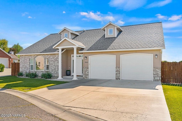 703 S 87th Ave, Yakima, WA 98908 - view of front of house with roof with shingles, concrete driveway, a garage, and brick siding