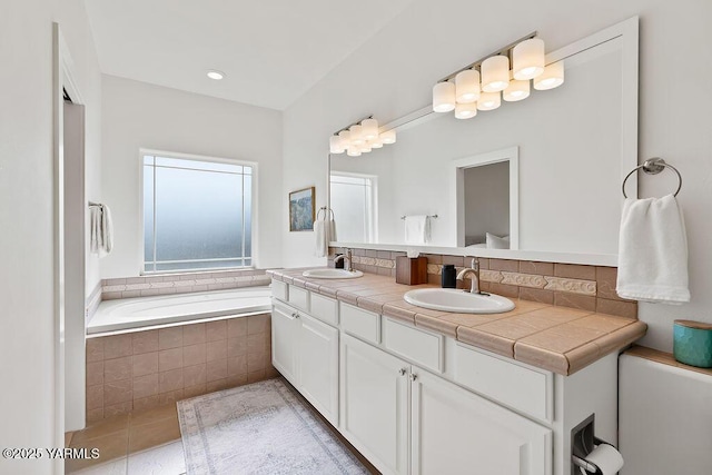 703 S 87th Ave, Yakima, WA 98908 - bathroom featuring double vanity, tiled tub, and tile patterned floors