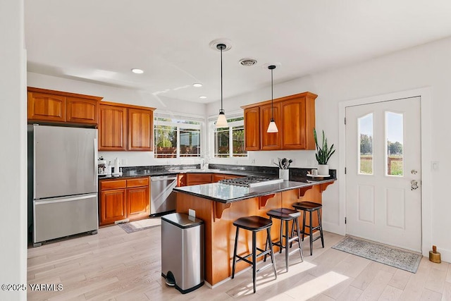 703 S 87th Ave, Yakima, WA 98908 - kitchen with stainless steel appliances, a peninsula, brown cabinets, recessed lighting, and light wood-type flooring