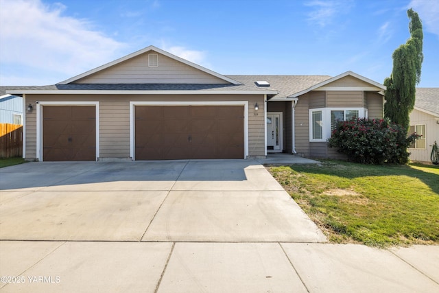 single story home with a shingled roof, a front yard, concrete driveway, and an attached garage