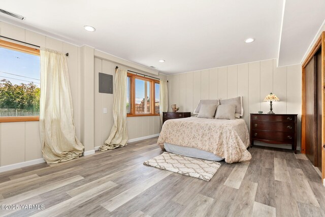 5306 Douglas Dr, Yakima, WA 98908 - bedroom featuring multiple windows, light wood-type flooring, a decorative wall, and baseboards
