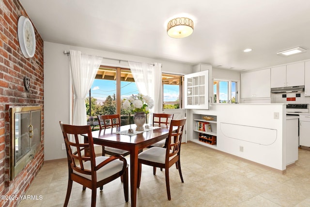 5306 Douglas Dr, Yakima, WA 98908 - dining space featuring plenty of natural light, baseboards, light tile patterned floors, a brick fireplace, and brick wall