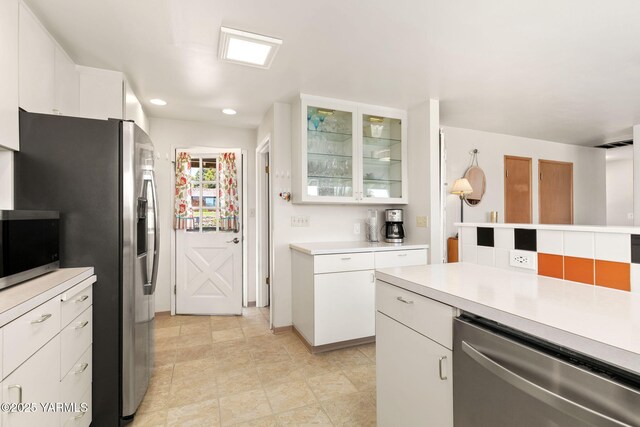 5306 Douglas Dr, Yakima, WA 98908 - kitchen featuring appliances with stainless steel finishes, light countertops, white cabinets, glass insert cabinets, and recessed lighting