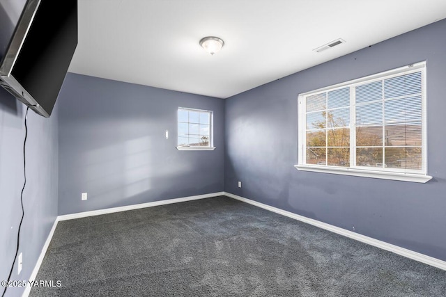 empty room featuring carpet, visible vents, and baseboards