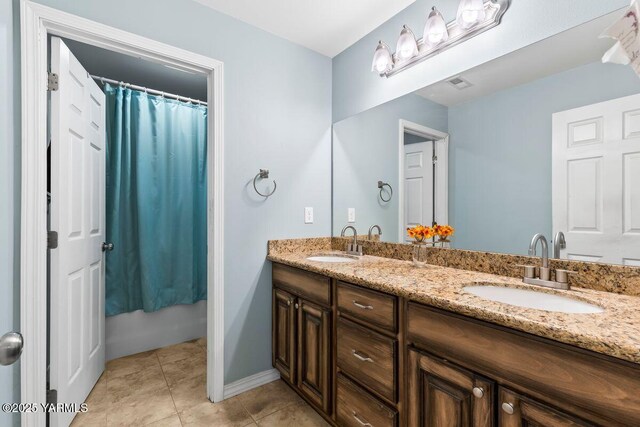 bathroom featuring double vanity, tile patterned flooring, visible vents, and a sink