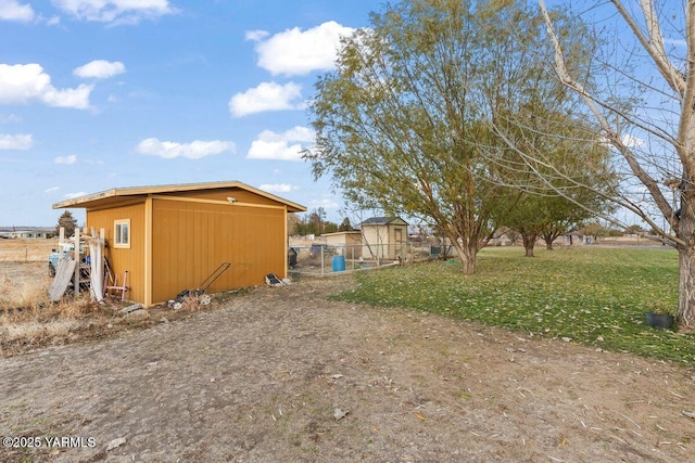 exterior space with a storage shed, fence, and an outbuilding