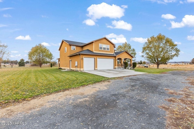 view of front of home with a garage, driveway, a front lawn, and stucco siding