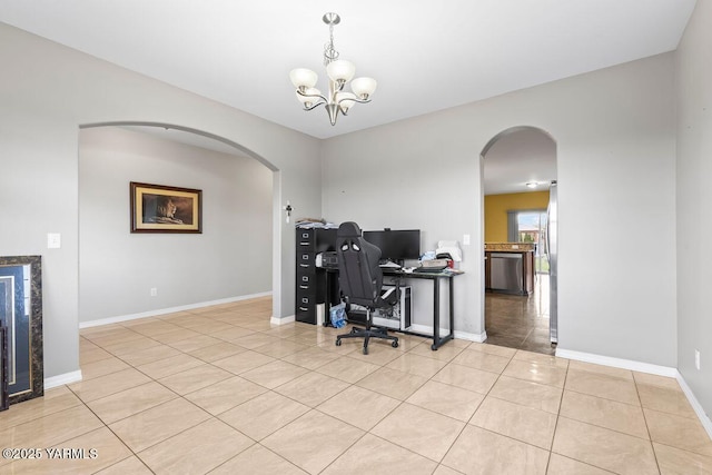 office featuring a chandelier, arched walkways, light tile patterned flooring, and baseboards