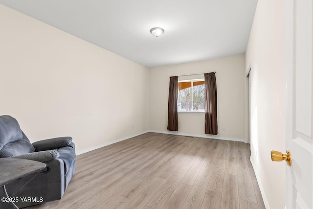 living area featuring light wood-type flooring and baseboards