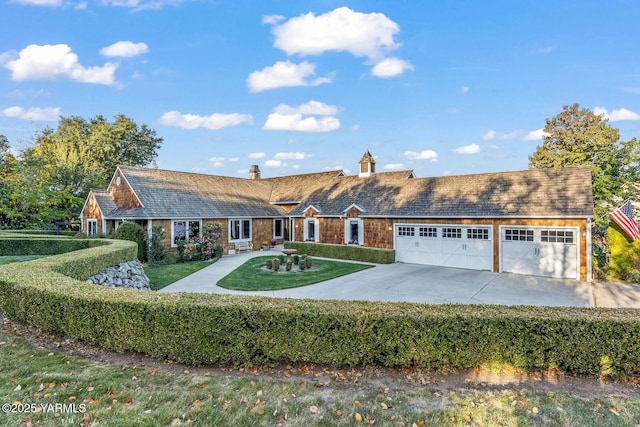 view of front of house featuring an attached garage, a front yard, concrete driveway, and a chimney