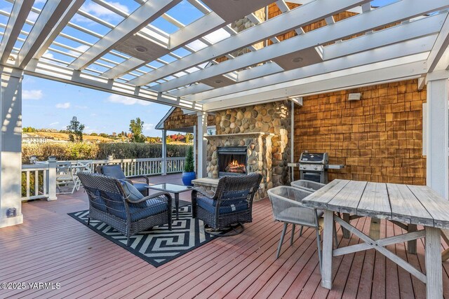 deck with area for grilling, outdoor dining space, an outdoor living space with a fireplace, and a pergola