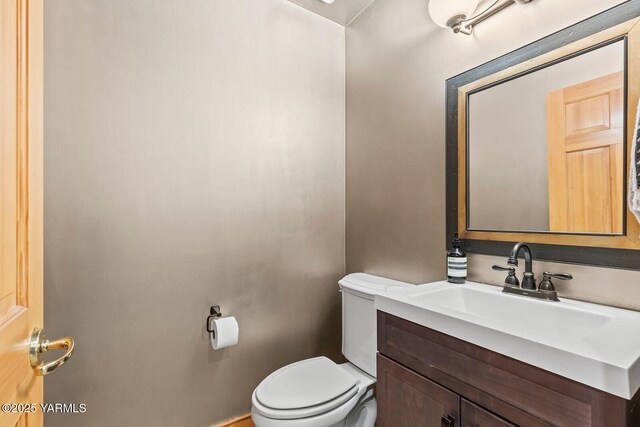 half bathroom with toilet and vanity